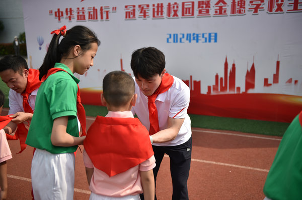 齐广璞为新入队的学生佩戴红领巾。主办方供图